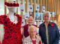 Gillin Park Community residents Gwen Mounsey, Elwyn Jasper and Melva Lloyd with their hand-knitted poppy dress ahead of Anzac Day 2024.