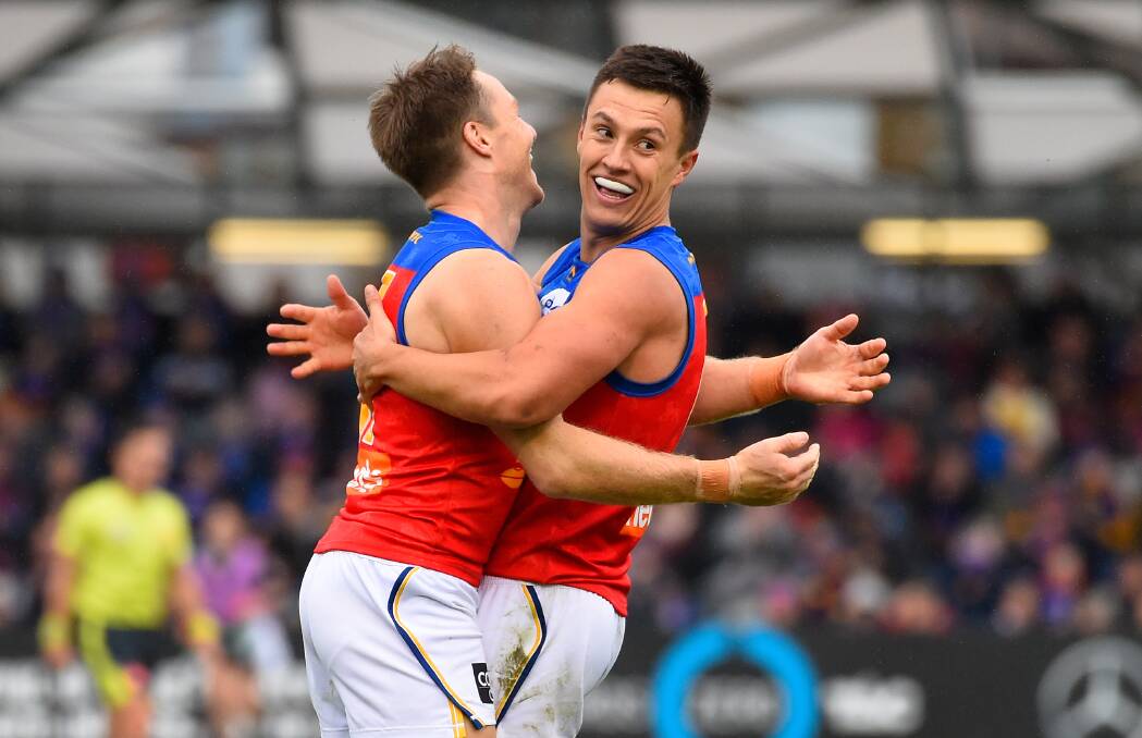 Hugh McCluggage embraces former Lions teammate Alex Witherden in 2019. Picture by Adam Trafford