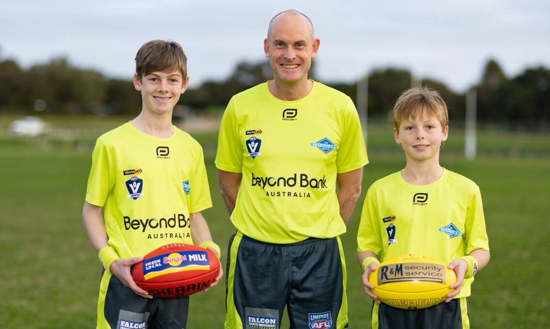 Warrnambool football umpire Andrew Lougheed with sons Michael, 13 and Aaron, 11, ahead of his 400th game for the association on Saturday. Picture by Sean McKenna
