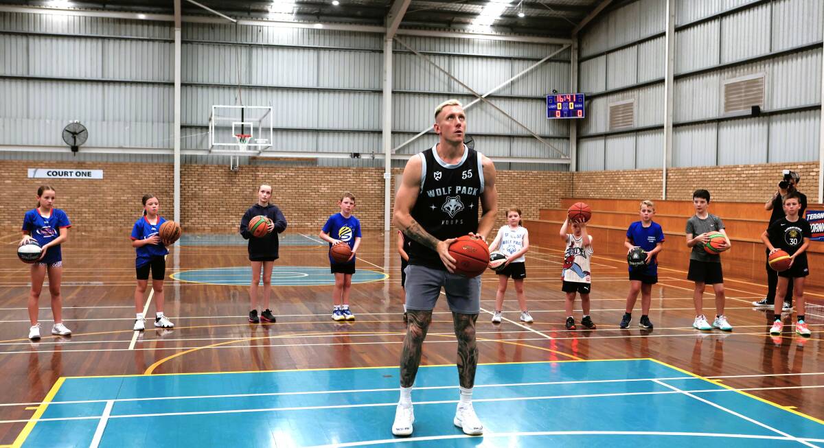 NBL superstar Mitch Creek demonstrates a shooting drill to the Terang junior basketballers. Picture by Anthony Brady