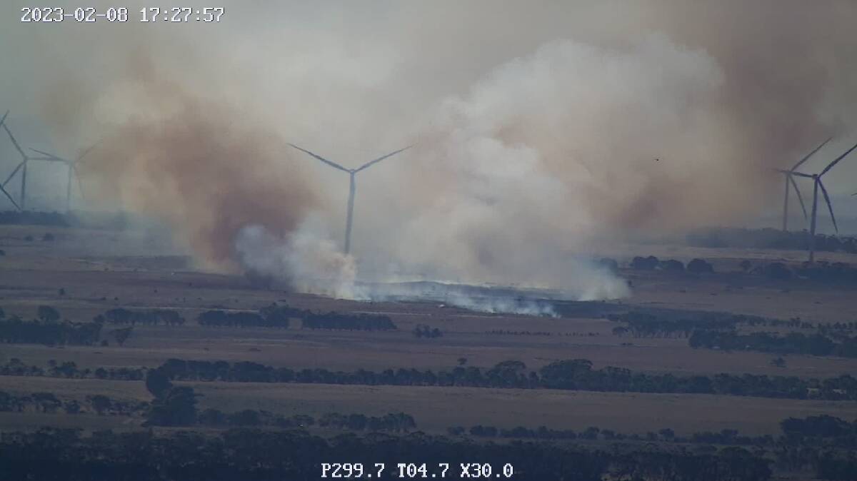One turbine is under particular threat from the approaching fire, with an aircraft on scene assessing the situation.