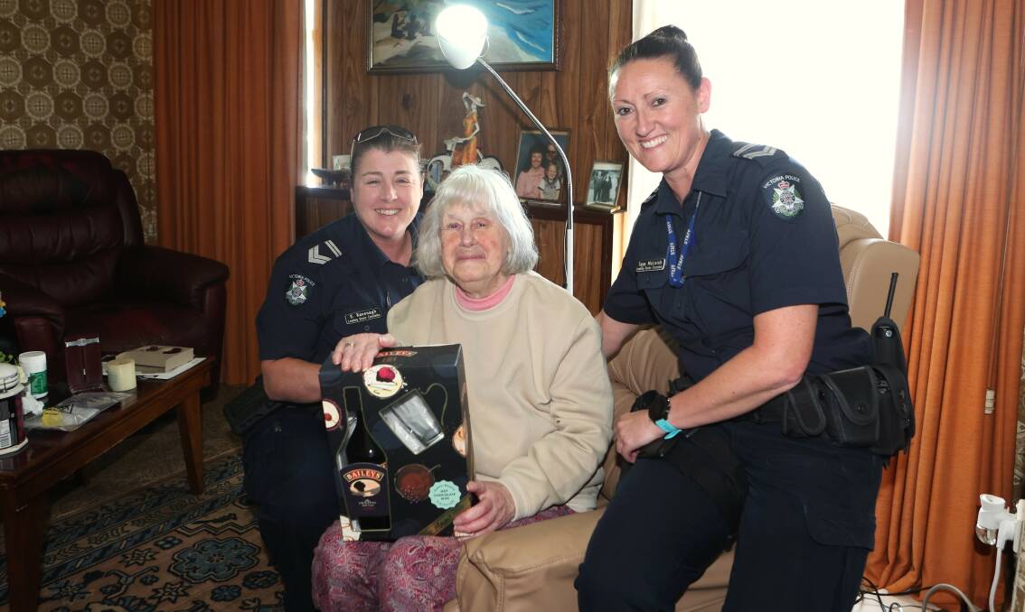 Warrnambool police Leading Senior Constables Shannon Kavenagh and Taya McLeish with the bottle of Baileys they gifted aggravated burglary victim and widow Margaret Tom. Picture by Anthony Brady