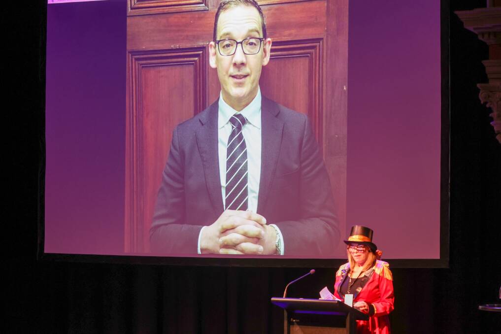 Tourism, Sport and Major Events for Creative Industries minister Steve Dimopoulos presented at the Warrnambool conference via video, while Great Ocean Road Regional Tourism general manager Liz Price stands on stage. Picture by Eddie Guerrero