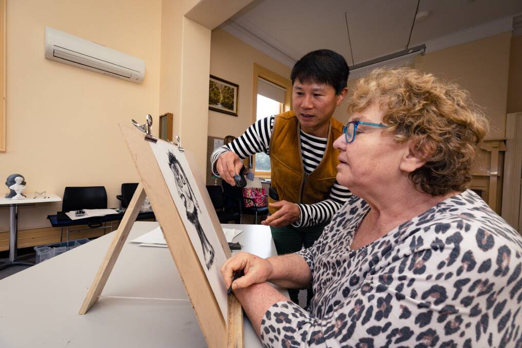 Artist and drawing instructor Sy Yoo with student Shirley Morgan. Picture by Sean McKenna