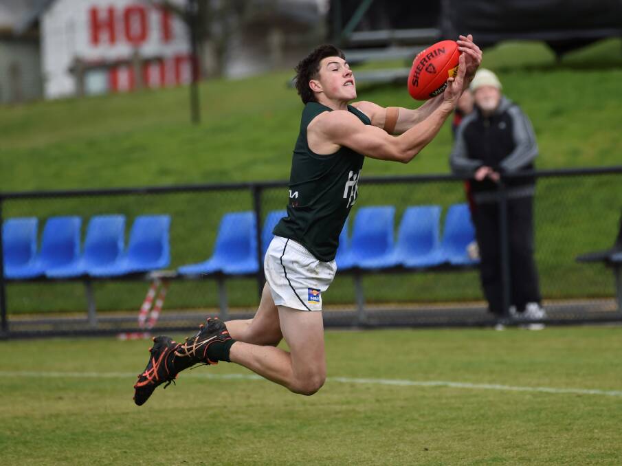 Hampden interleague captain Paddy O'Sullivan launches for the mark on Saturday. Picture by Lachlan Bence