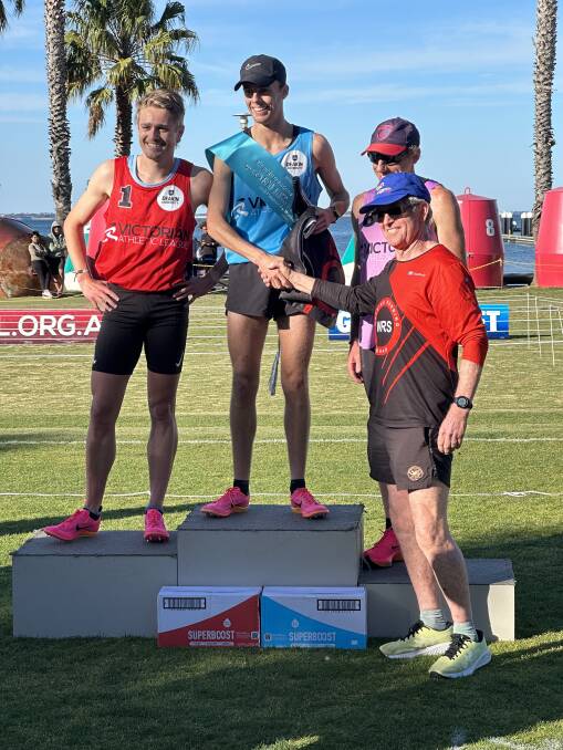 Warrnambool's Josh Bail is presented his 800-metre open sash at Geelong Gift by coach Graeme Watkins. Picture by Ian Bail