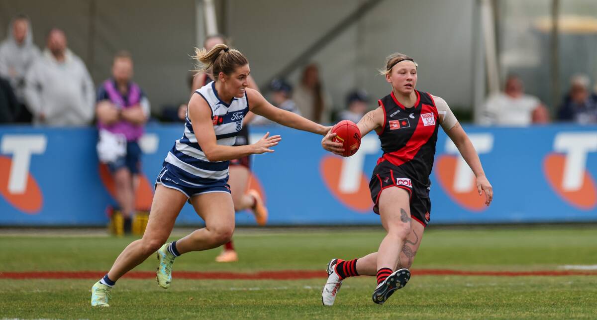 Essendon's Paige Scott keeps a step ahead of Geelong's Becky Webster. Picture by Sean McKenna.