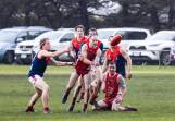 Dennington captain Tom Fitzgerald dishes off a handball in the rainy conditions against Timboon Demons. Pictures by Anthony Brady