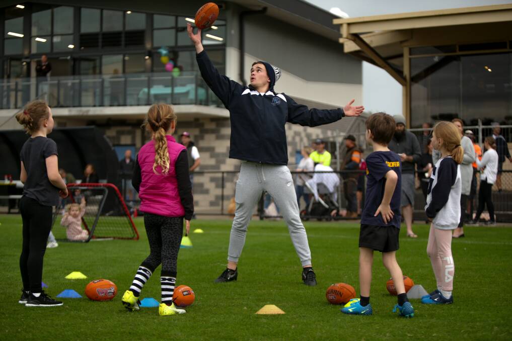 THIS IS HOW YOU DO IT: Warrnambool Football Club's Will Woolstencroft coaches children at the Reid Oval opening on Friday. Picture: Chris Doheny