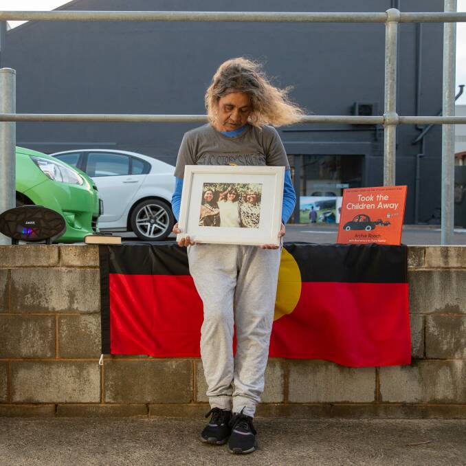 Stolen generation child Tracy Roach holds a photo of her and her mother during a protest of the continued removal of Aboriginal children from their homes.
