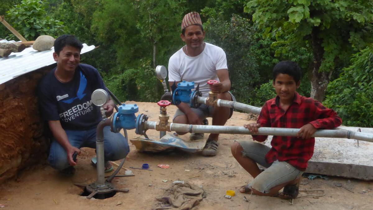 Progress: Locals show off the new equipment that returned running water to the village left devestated by the 2015 earthquake.
