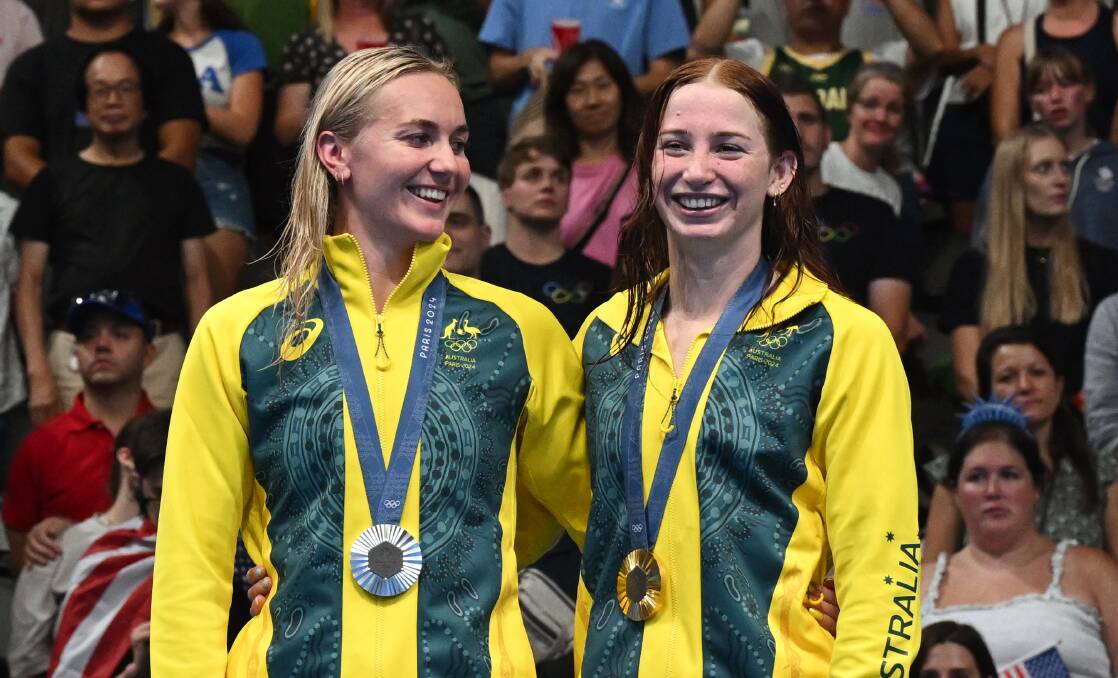 Queenslander Mollie O'Callaghan invited Launceston product Ariarne Titmus onto the gold medal dais in one of the great Olympic moments. Picture by AAP