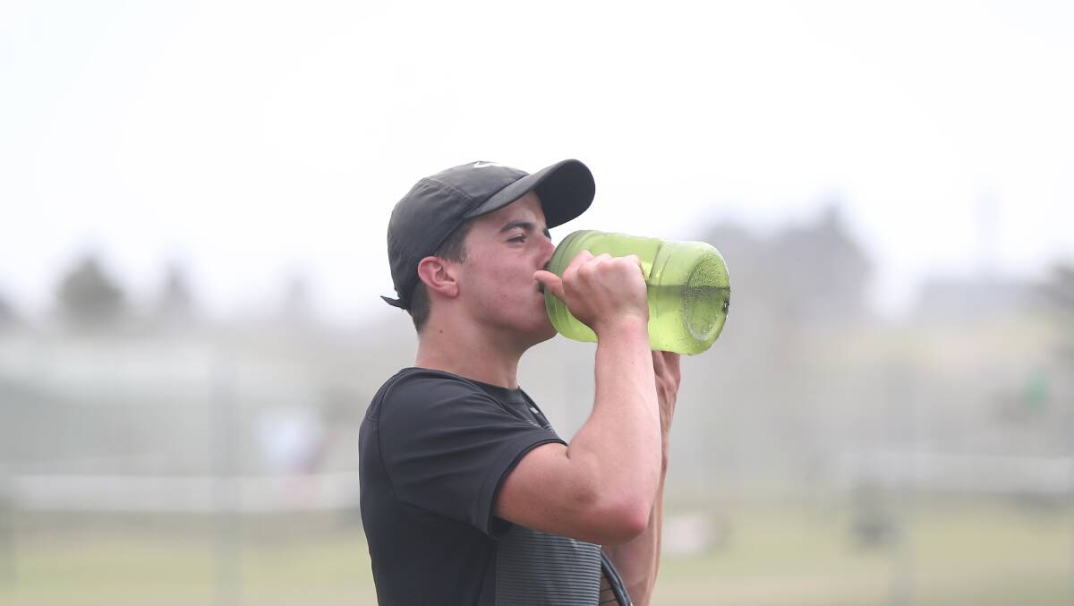Refreshing: Warrnambool's Ned Timms takes a drink during his match before it was called off due to the heat rule. Picture: Mark Witte