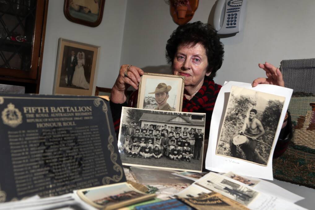 Judith McKenzie is pictured here with photos of her brother Graham Warburton, who was killed in Vietnam just three weeks after his 21st birthday.