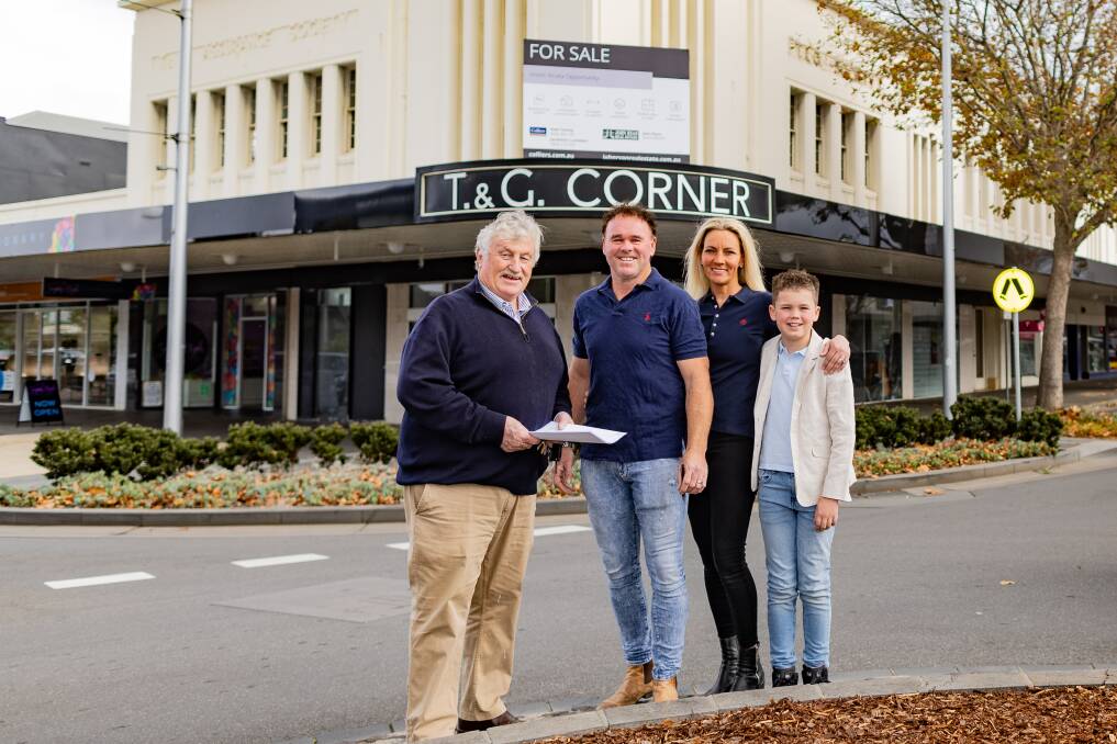 Real estate agent John Ryan with Clayton, Jacinta and Braxton Harrington with the famous T&G corner in the background. Picture by Anthony Brady 