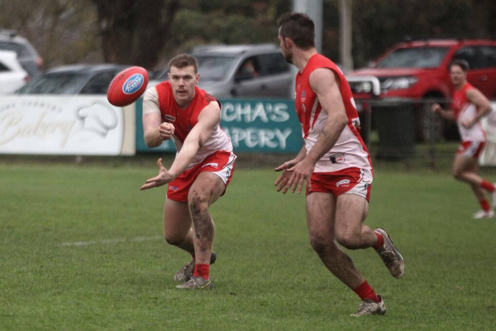South Warrnambool defender Isaac Thomas dishes off a handball during the Roosters' second semi-final win against North Warrnambool Eagles. Picture by Meg Saultry 