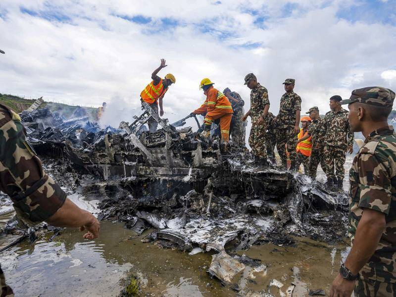 Army personnel sort through the debris of a plane that crashed during take-off in Kathmandu. Photo: AP PHOTO