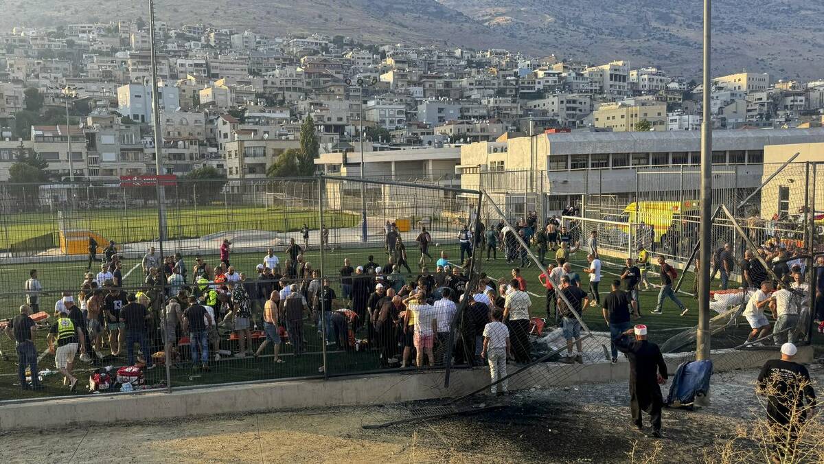 Paramedics rushed to help children after the rocket attack hit a soccer field in Golan Heights. (AP PHOTO)