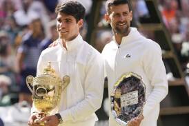 Young Spanish gun Carlos Alcaraz holds the Wimbledon winner's trophy alongside Novak Djokovic. (AP PHOTO)