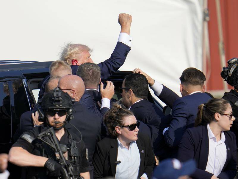 Secret Service agents quickly escorted a bloodied Donald Trump off stage following the shooting. Photo: AP PHOTO