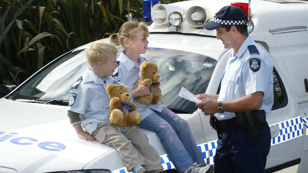 Constable Greg Kew with Carly McLaren, 7, and her brother Mitchell, with one of her drawings.
