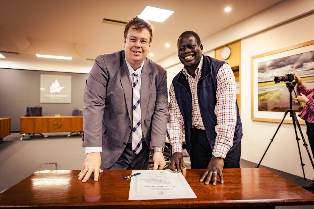 Ben Blain and Thomas Lual with the Refugee Welcome Zone document. Picture by Sean McKenna.