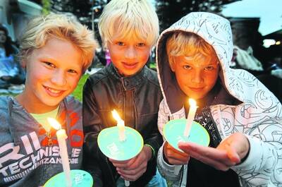 The Howard siblings William, 13, Ben, 9, and Tom, 7, get into the festive cheer at last night's carols on the Civic Green.