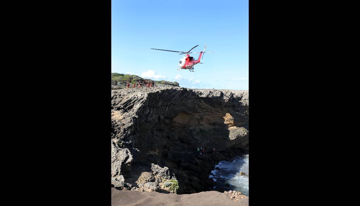 The rescue helicopter prepares to winch the woman.
