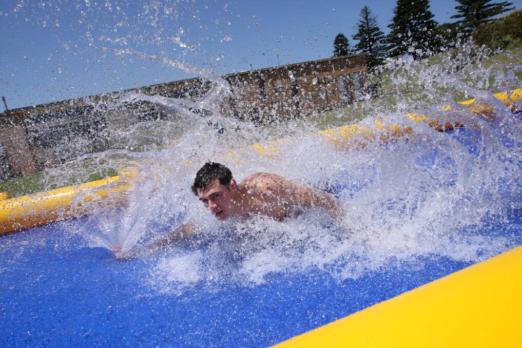 Lifeguard Adam Barnes and fellow Aquazone staff members try out their new slippery slide. Picture: VICKY HUGHSON