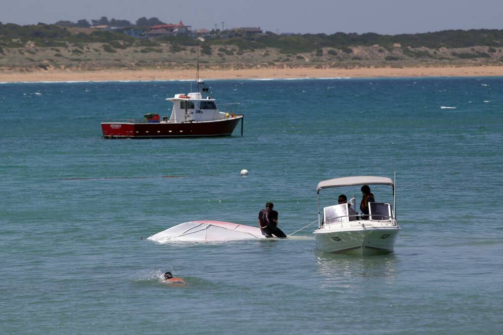 Fishermen from Melbourne capsized their fishing boat at the breakwater. Picture: DAMIAN WHITE